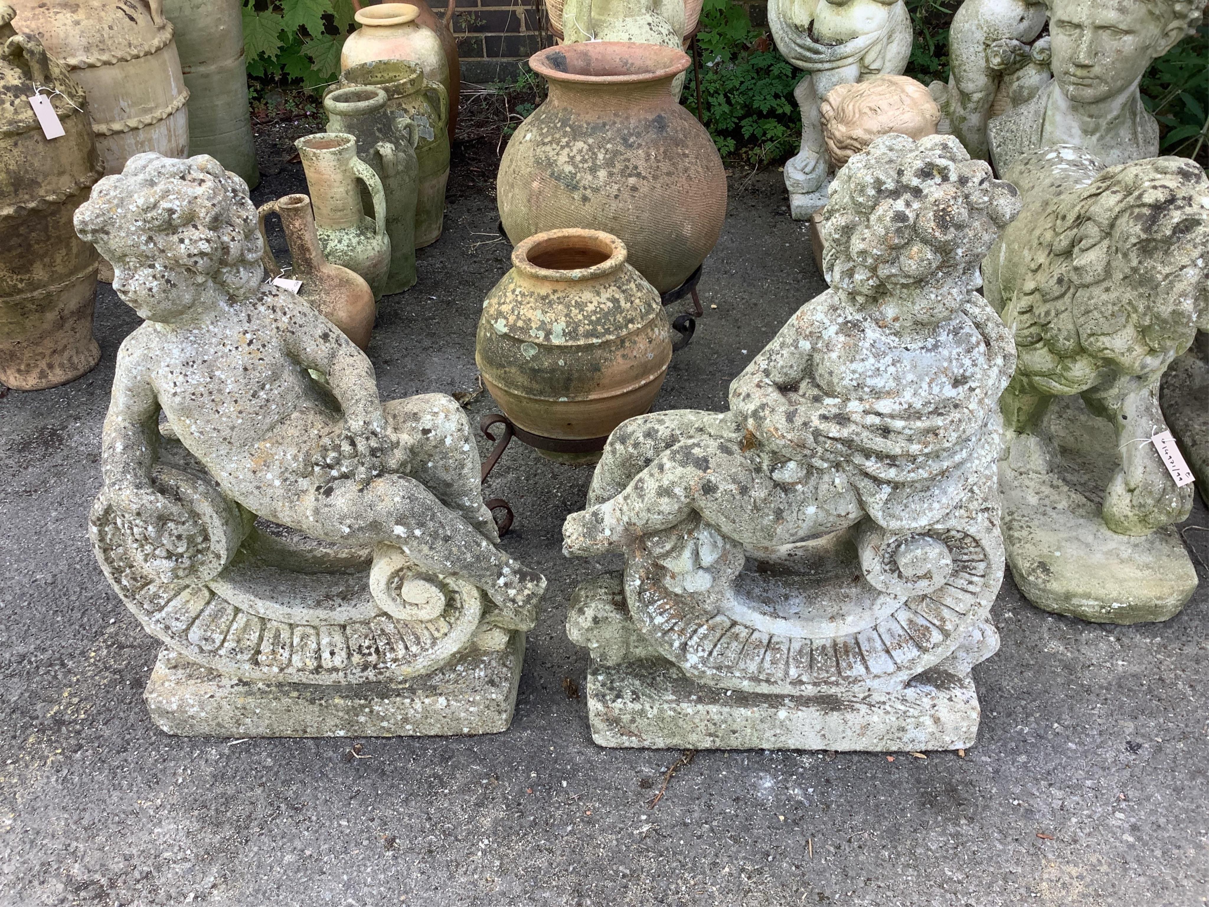 A pair of reconstituted stone putti and scroll garden ornaments, height 68cm. Condition - poor to fair